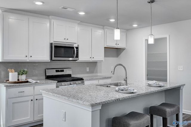 117 Huffman St, Hazel Green, AL 35750 - kitchen with an island with sink, white cabinets, stainless steel appliances, and a sink