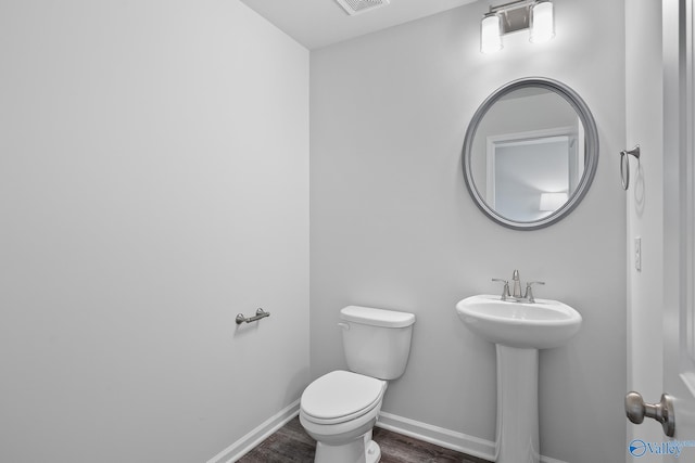 117 Huffman St, Hazel Green, AL 35750 - half bath with visible vents, toilet, a sink, wood finished floors, and baseboards