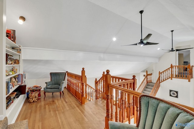 sitting room featuring an upstairs landing, a ceiling fan, light wood finished floors, and vaulted ceiling