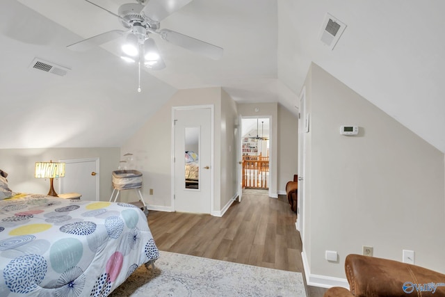 bedroom featuring lofted ceiling, visible vents, wood finished floors, and baseboards