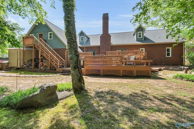 rear view of property featuring a deck, stairs, and brick siding