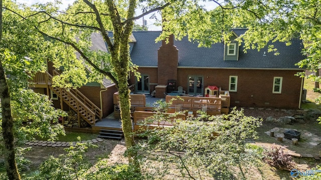 back of property with brick siding, french doors, a wooden deck, and stairs