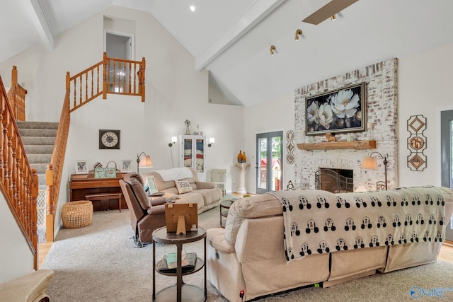 living area with stairway, high vaulted ceiling, beamed ceiling, and a brick fireplace