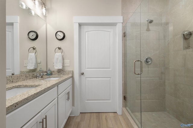 413 Lando Cain Rd, Hartselle, AL 35640 - bathroom with a stall shower, double vanity, and wood finished floors