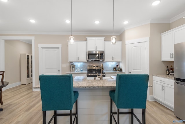 413 Lando Cain Rd, Hartselle, AL 35640 - kitchen with appliances with stainless steel finishes, a breakfast bar area, decorative backsplash, crown molding, and white cabinets