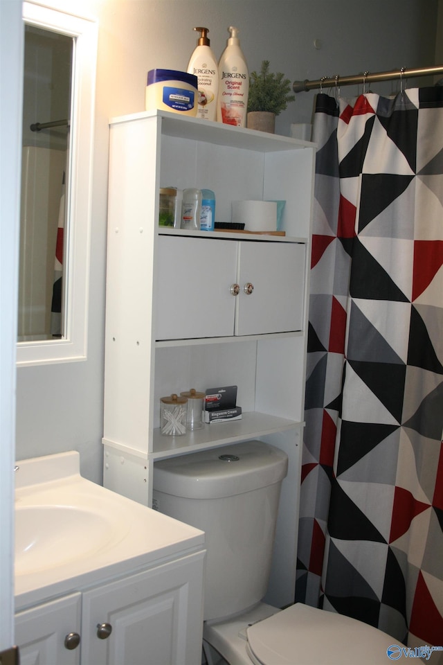 bathroom featuring walk in shower, vanity, and toilet