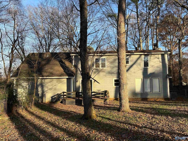 view of side of home with a wooden deck and a yard