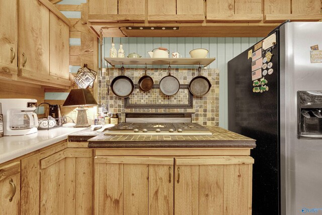 kitchen with appliances with stainless steel finishes, decorative backsplash, and light brown cabinetry