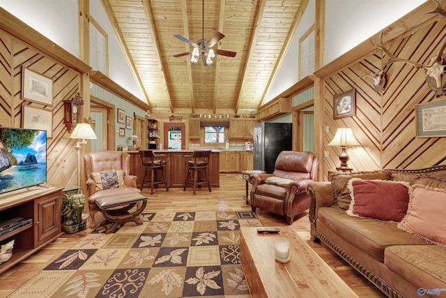 living room with wood walls, high vaulted ceiling, beam ceiling, light hardwood / wood-style floors, and wood ceiling