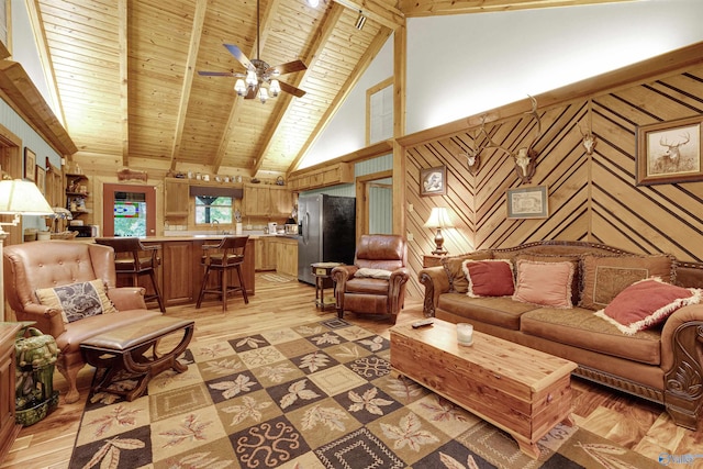 living room featuring sink, beamed ceiling, light hardwood / wood-style flooring, ceiling fan, and wood ceiling