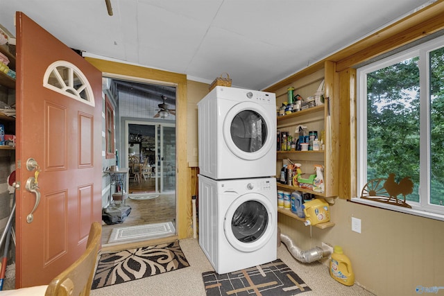 washroom with ceiling fan, stacked washer / drying machine, and carpet