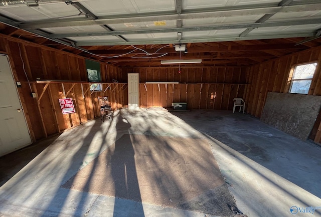 garage with a garage door opener and wooden walls