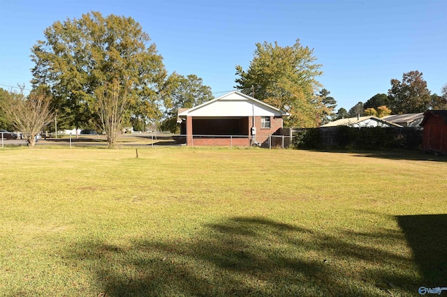 view of yard with fence and an outbuilding