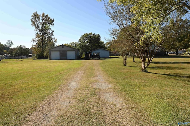 view of front of house with a garage, an outdoor structure, driveway, and a front lawn