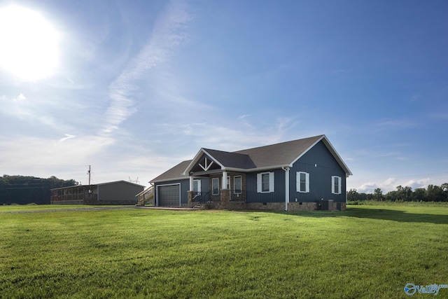 view of front of house with a garage, central AC, and a front yard