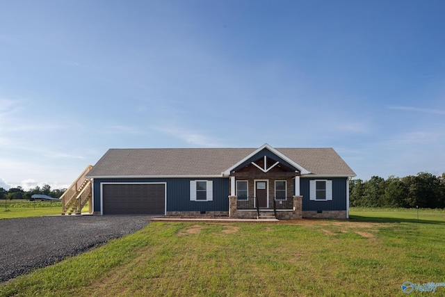 view of front of house featuring a front yard, a porch, and a garage