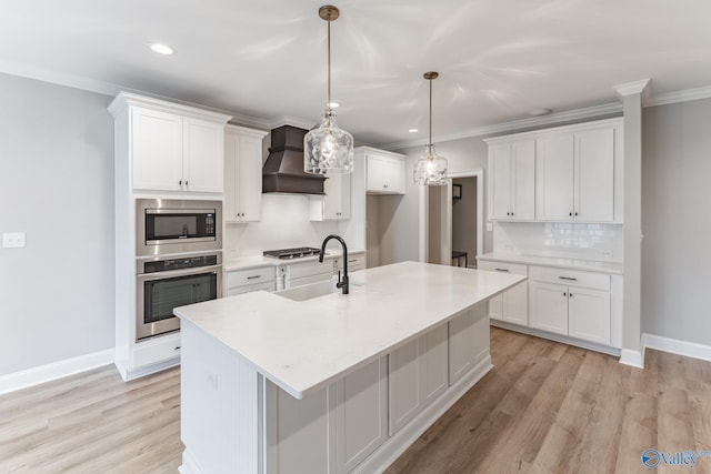 kitchen with sink, premium range hood, white cabinets, and appliances with stainless steel finishes