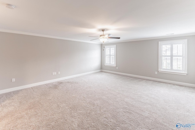 carpeted spare room featuring crown molding and ceiling fan