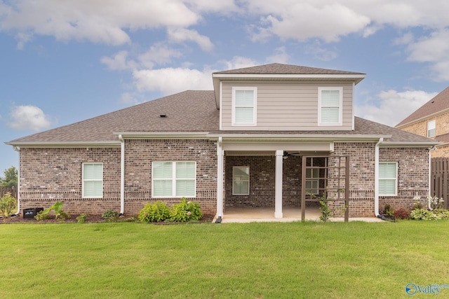 rear view of property with a yard, a patio area, and ceiling fan