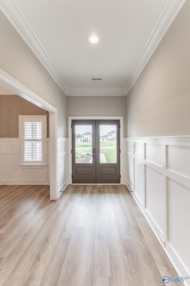 doorway to outside with french doors, ornamental molding, a healthy amount of sunlight, and light hardwood / wood-style floors