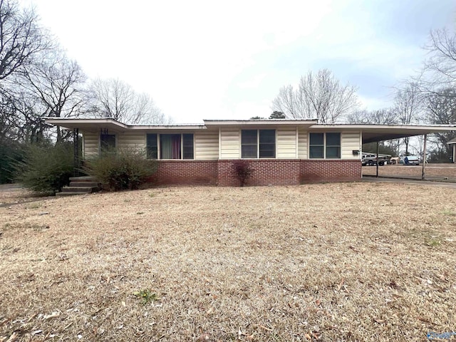 ranch-style home with a carport and a front lawn