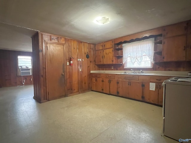 kitchen with cooling unit, white electric range oven, sink, and wood walls