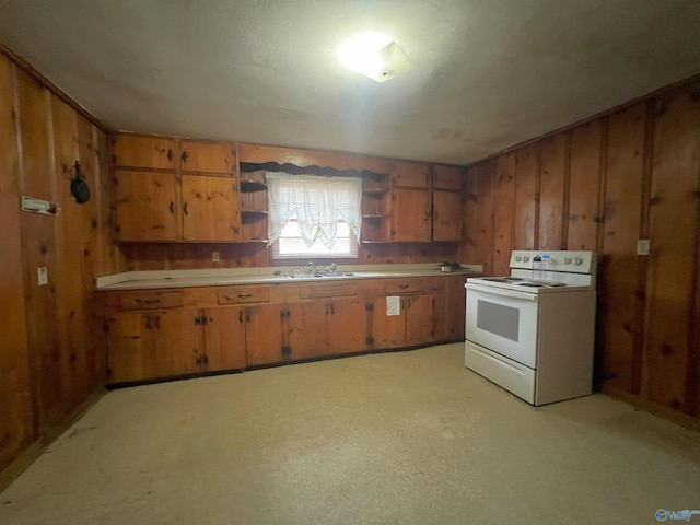 kitchen featuring sink, white electric range oven, and wood walls