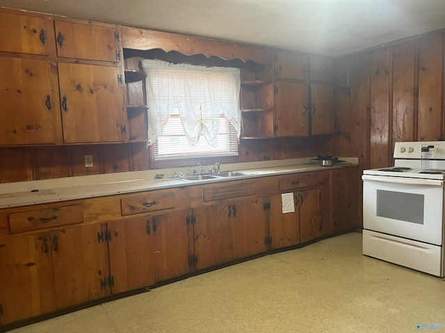 kitchen featuring sink, wood walls, and white electric range oven