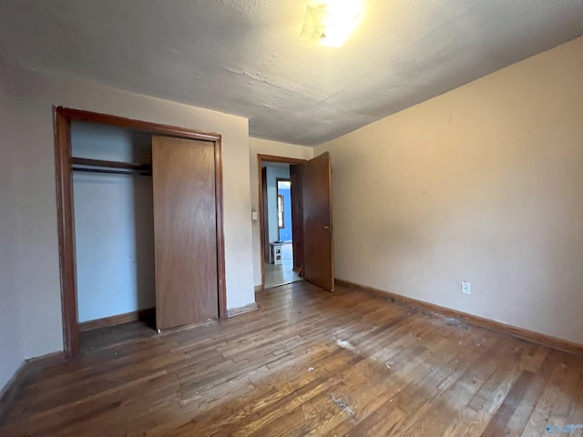 unfurnished bedroom featuring hardwood / wood-style flooring, a closet, and a textured ceiling