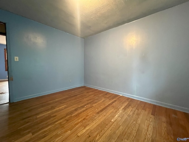 empty room featuring hardwood / wood-style flooring and a textured ceiling