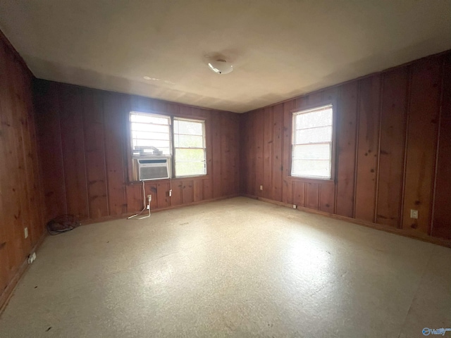 empty room featuring cooling unit and wooden walls