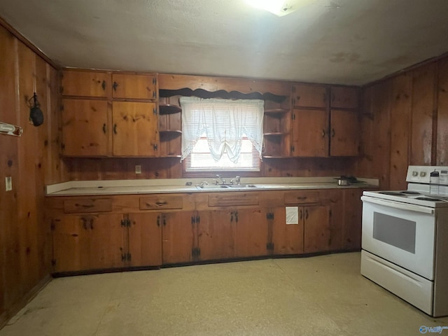 kitchen featuring wooden walls, white electric range oven, and sink