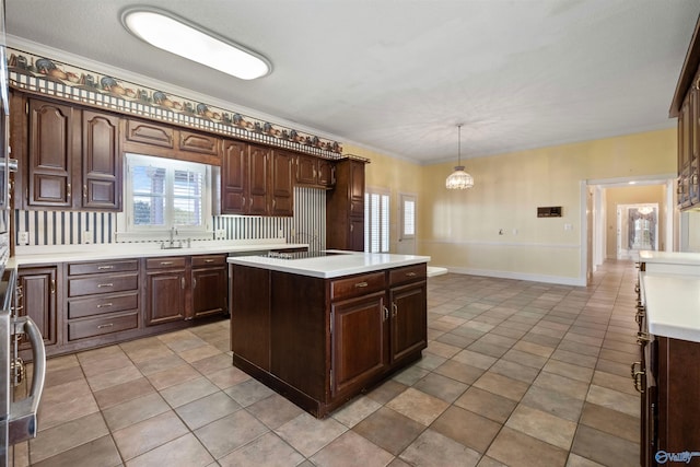 kitchen with pendant lighting, sink, dark brown cabinetry, light tile patterned floors, and a kitchen island with sink