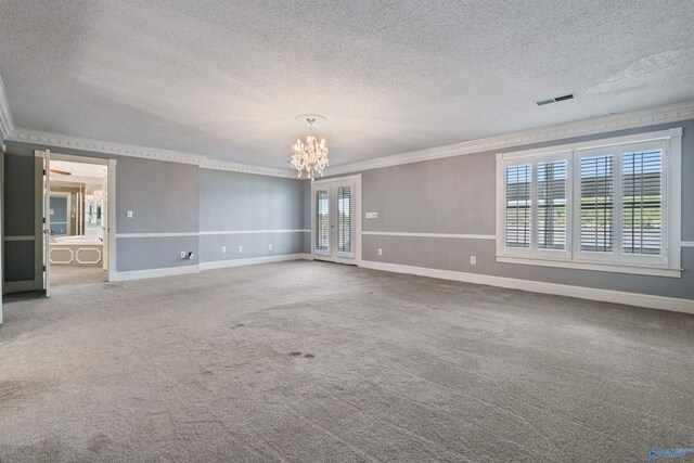 empty room featuring carpet floors, crown molding, an inviting chandelier, and a textured ceiling