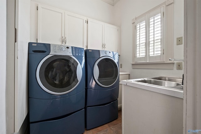 laundry room featuring sink, washer and dryer, dark tile patterned flooring, and cabinets