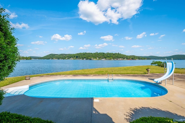 view of pool featuring a water view, a patio area, and a water slide