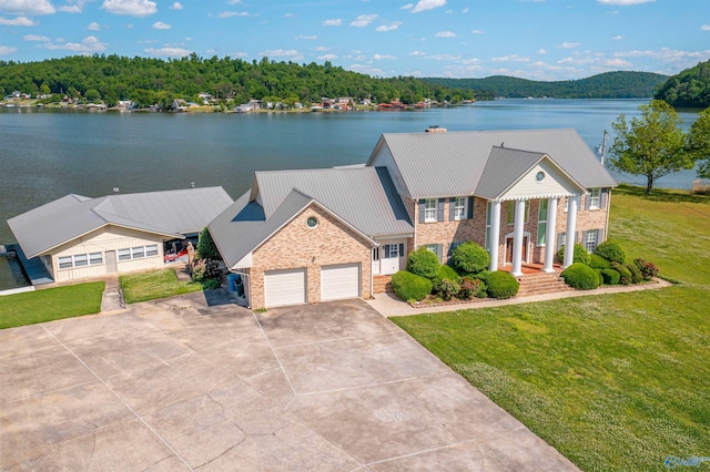 view of front of property with a garage, a water view, and a front yard