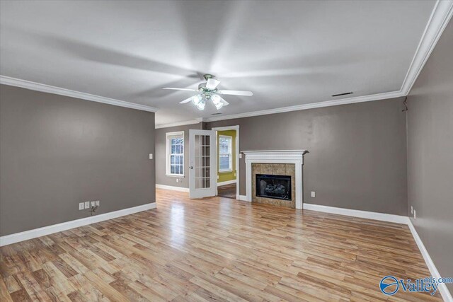 unfurnished living room featuring crown molding, a fireplace, ceiling fan, and light wood-type flooring