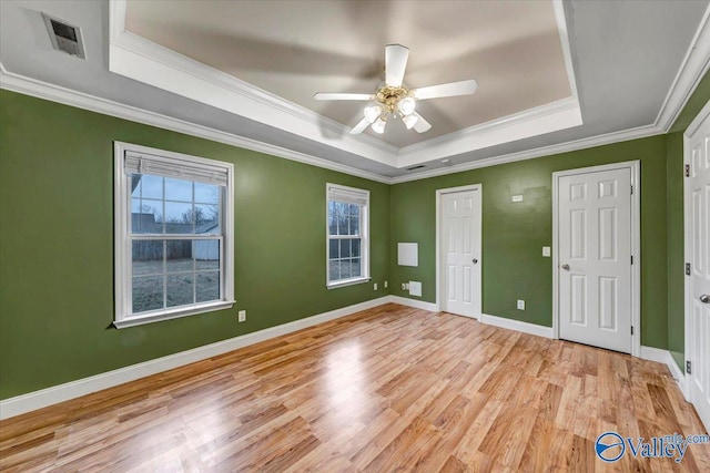 unfurnished room featuring a tray ceiling, ceiling fan, and ornamental molding