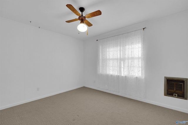 carpeted empty room with heating unit and ceiling fan