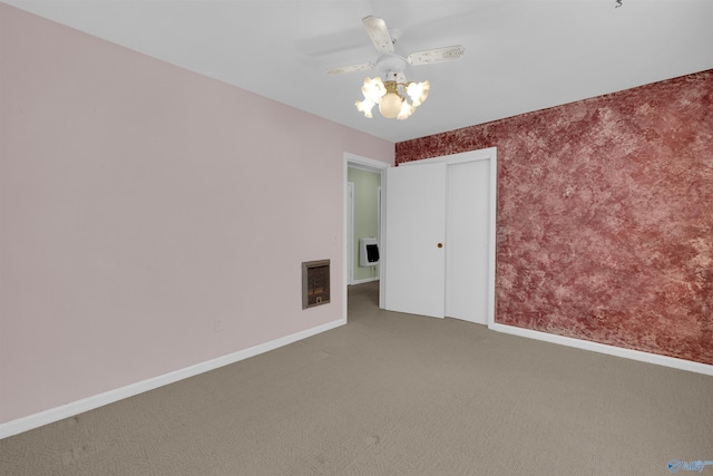 unfurnished bedroom with heating unit, ceiling fan, and carpet