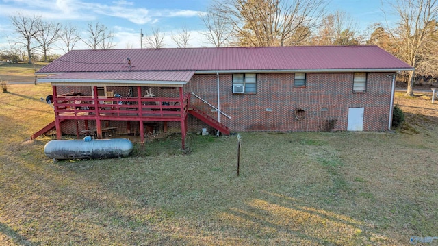 rear view of house featuring a lawn and a wooden deck