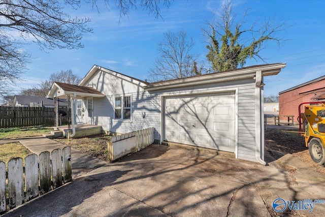 view of front of property featuring a garage, driveway, board and batten siding, and fence