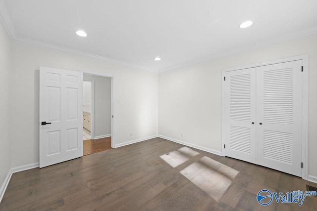 unfurnished bedroom with dark hardwood / wood-style floors, a closet, and crown molding