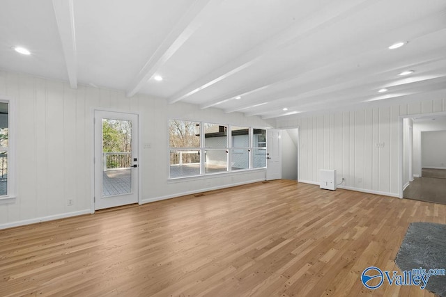 unfurnished living room with beamed ceiling and light hardwood / wood-style flooring