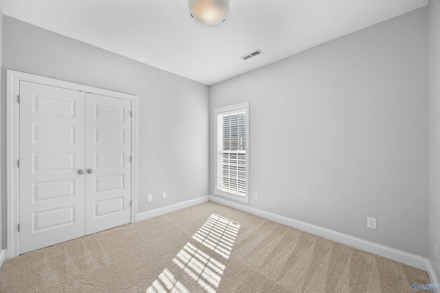 unfurnished bedroom with carpet flooring and a closet