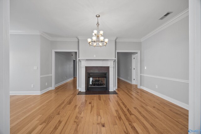 unfurnished living room with a chandelier, light hardwood / wood-style floors, and ornamental molding