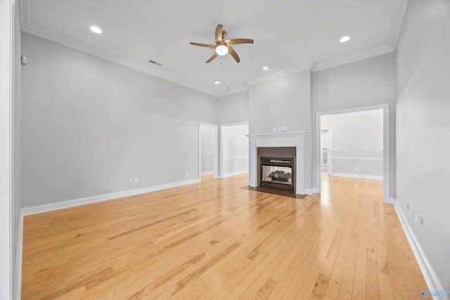 unfurnished living room featuring a towering ceiling, light hardwood / wood-style flooring, ceiling fan, and ornamental molding