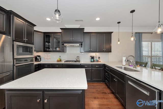 kitchen with appliances with stainless steel finishes, crown molding, sink, decorative light fixtures, and dark hardwood / wood-style floors