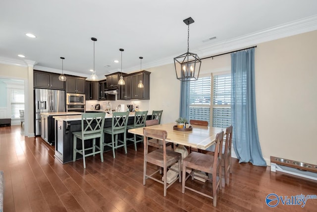 dining area with sink, ornamental molding, and dark wood-type flooring